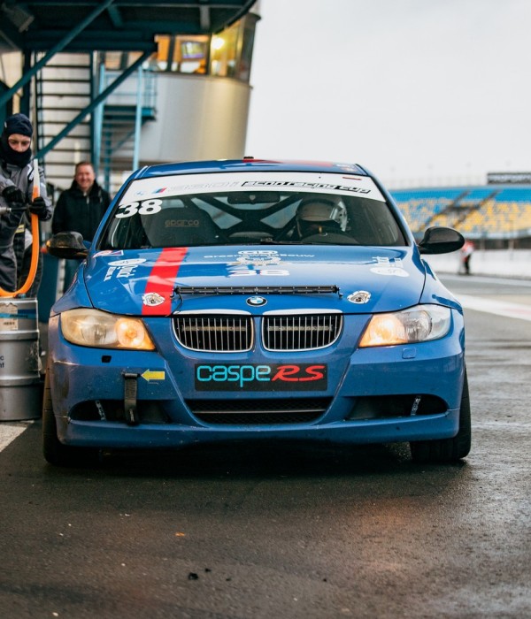 BMW 1-serie met brandende koplampen in de schemering op TT Circuit Assen