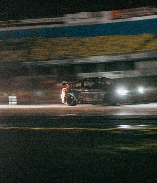 Raceauto met koplampen aan tijdens het donkere deel van Into The Dark