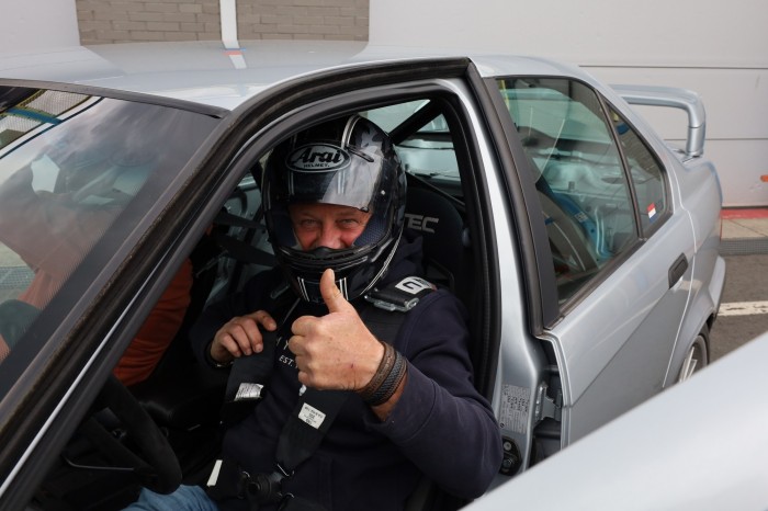 Coureur in een auto met de duim omhoog
