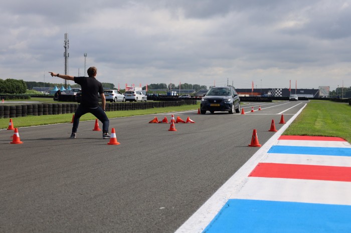 Coureur in een auto met de duim omhoog