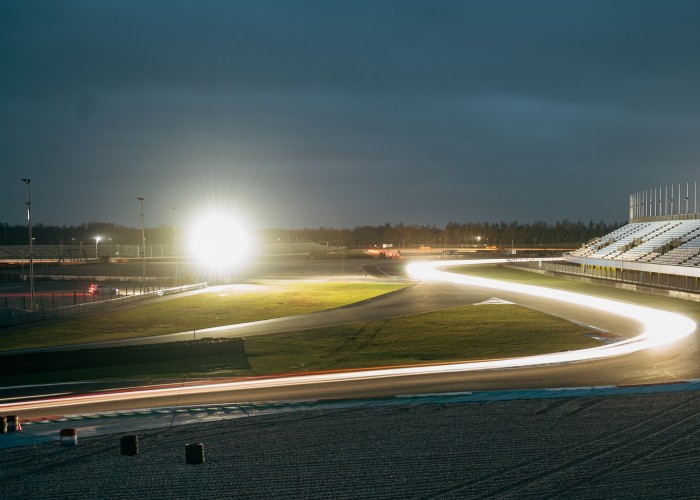 Lichtsporen van raceauto's op TT Circuit Assen na zonsondergang